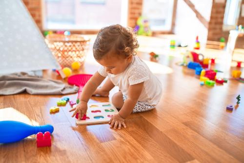 child on floor playing with blocks