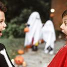 two shocked kids in costumes looking at each other